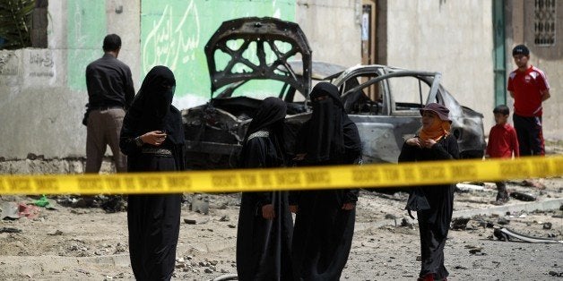 Yemenis walk on June 18, 2015 near the wreckage of cars after five simultaneous bombings targeting Shiite mosques and offices hit the Yemeni capital Sanaa the previous night killing at least 31 people. The Islamic State group, a Sunni Muslim radical group, said the attacks were in 'revenge' against the Shiite Huthis, who have overrun Sanaa and much of the Sunni majority country and whom it considers to be heretics. AFP PHOTO / MOHAMMED HUWAIS (Photo credit should read MOHAMMED HUWAIS/AFP/Getty Images)