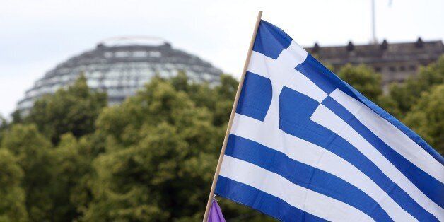 A Greek national flag flies in front of the Reichstag building, seat of the German federal parliament, during a Blockupy demonstration in Berlin on June 20, 2015. Approximately 1,800 demonstrators marched for support of Greece amidst the country's economic crisis as well as for aid to refugees coming to Europe. AFP PHOTO / ADAM BERRY (Photo credit should read ADAM BERRY/AFP/Getty Images)