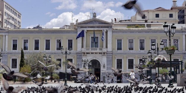 Pigeons fly in front of the National Bank of Greece headquarters in central Athens on June 23, 2015. Hopes that Greece and it