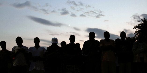 Migrants pray at the Franco-Italian border in Ventimiglia, Italy, during the holy month of Ramadan, Friday, June 19, 2015. The European Union will move ahead beginning next week on a plan to disrupt the business model of human traffickers in the Mediterranean Sea, diplomats said, speaking to the media Friday on condition of anonymity. (AP Photo/Thibault Camus)