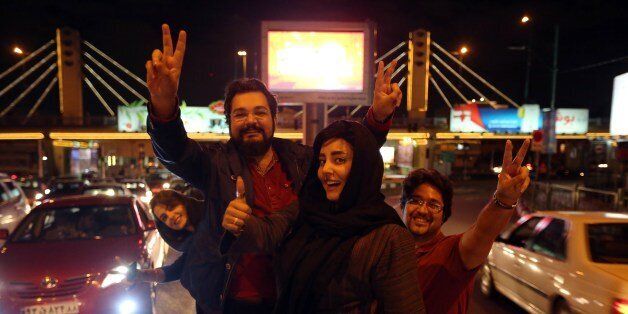 People flash the 'V for Victory' sign as they celebrate on Valiasr street in northern Tehran on April 2, 2015, after the announcement of an agreement on Iran nuclear talks. Iran and global powers sealed a deal on April 2 on plans to curb Tehran's chances for getting a nuclear bomb, laying the ground for a new relationship between the Islamic republic and the West. AFP PHOTO / ATTA KENARE (Photo credit should read ATTA KENARE/AFP/Getty Images)