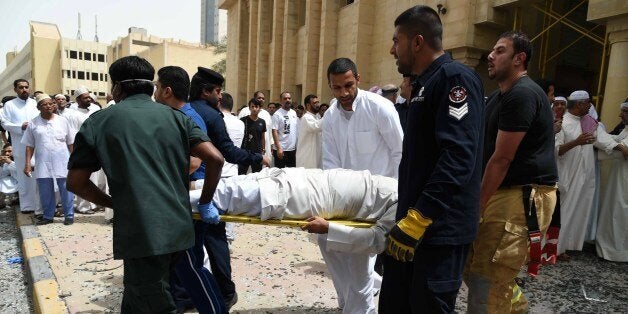 Kuwaiti security personnel and medical staff carry a man on a stretcher at the site of a suicide bombing that targeted the Shiite Al-Imam al-Sadeq mosque after it was targeted by a suicide bombing during Friday prayers on June 26, 2015, in Kuwait City. The Islamic State group-affiliated group in Saudi Arabia, calling itself Najd Province, said militant Abu Suleiman al-Muwahhid carried out the attack, which it claimed was spreading Shiite teachings among Sunni Muslims. AFP PHOTO / STR (Photo credit should read STR/AFP/Getty Images)