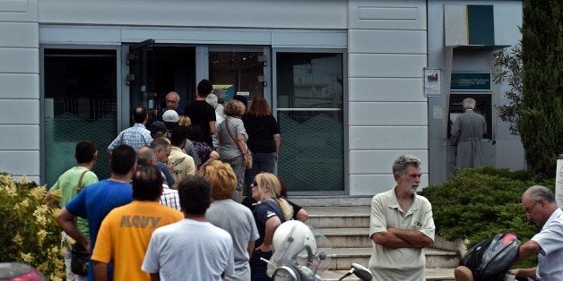 People queue at a national Bank of Greece ATM in central Athens on June 27, 2015. Eurozone ministers meet in Brussels on June 27 for a crunch meeting after a shock call for a referendum by Greek Prime Minister Alexis Tsipras threw a push to avert a default by Athens into confusion. Greece will vote on July 5 on the outcome of negotiations with its international creditors that have dragged on since January, when Tsipras's Syriza party first took power on a promise of ending austerity. AFP PHOTO / ARIS MESSINIS (Photo credit should read ARIS MESSINIS/AFP/Getty Images)