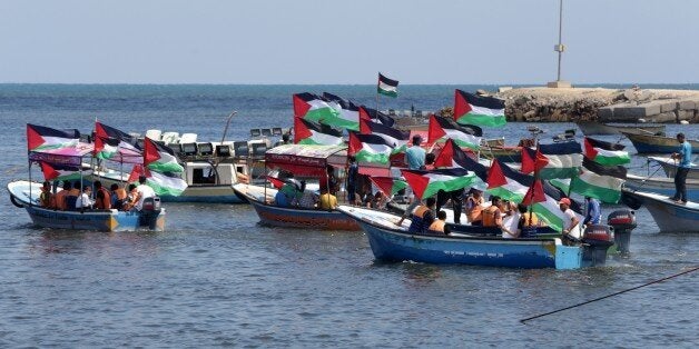 Palestinians hold their national flag as they ride boats during a rally to show support for activists aboard a flotilla of boats who are soon to set sail for Gaza in a fresh bid to break Israel's blockade of the territory, at the seaport of Gaza City on June 24, 2015. The so-called Freedom Flotilla III -- a convoy of ships carrying pro-Palestinian activists, at least one European lawmaker and an Arab-Israeli MP -- will try to reach the shores of the Gaza Strip by the end of the month. AFP PHOTO / MAHMUD HAMS (Photo credit should read MAHMUD HAMS/AFP/Getty Images)