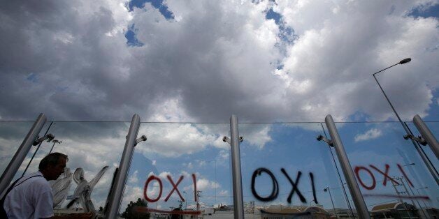 A worker cleans the word ''NO'' written in Greek with spray paint early morning calling for a ''No'' vote in the upcoming referendum, at the entrance of a suburban railway station in northern Athens, Sunday, June 28, 2015. The European Central Bank has announced it is maintaining emergency credit to Greek banks at its current level. The decision keeps a key financial lifeline open but does not provide further credit to Greece's banks, which are seeing deposits drain away as many anxious Greeks withdraw savings. (AP Photo/Thanassis Stavrakis)