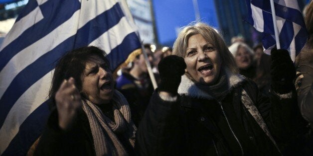 People shout slogans and wave Greek flags during an anti-austerity, pro-government rally in front of the Greek Parliament in Athens on February 15, 2015. At least 18,000 people rallied in front of parliament in Athens ahead of talks in Brussels on the new leftist government's bid to revise its bailout. AFP PHOTO / ANGELOS TZORTZINIS (Photo credit should read ANGELOS TZORTZINIS/AFP/Getty Images)