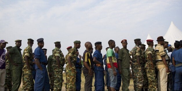 Civilians, army soldiers and police queue to vote in the opposition stronghold of Musaga in Bujumbura on June 29, 2015. Voting in Burundi's controversial elections opened despite a string of grenade attacks in polling stations, the latest in weeks of violence sparked by the president's defiant bid for a third term. AFP PHOTO / PHIL MOORE (Photo credit should read PHIL MOORE/AFP/Getty Images)