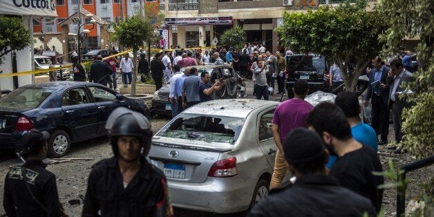 Egyptian security forces stand guard at the site of a bomb that targeted the convoy of the Egyptian state prosecutor, Hisham
