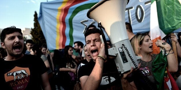 Protesters participate a demonstration in front of the Greek parliament in Athens on June 29, 2015. Greece shut its banks and the stock market and imposed capital controls after creditors at the weekend refused to extend the country's bailout past the June 30 deadline, prompting anxious citizens to empty ATMs. AFP PHOTO / ARIS MESSINIS (Photo credit should read ARIS MESSINIS/AFP/Getty Images)