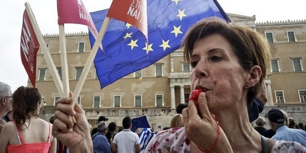 ATHENS, GREECE - JUNE 30: Demonstrators during a rally organized by supporters of the 'Yes' vote for the upcoming referendum in front of the Greek Parliament on June 30, 2015 in Athens, Greece. Greek voters will decide in a referendum next Sunday on whether their government should accept an economic reform package put forth by Greece's creditors. Greece has imposed capital controls with the banks being closed until the referendum and a daily limit of 60 euros has been placed on cash withdrawals from ATMs. (Photo by Milos Bicanski/Getty Images)