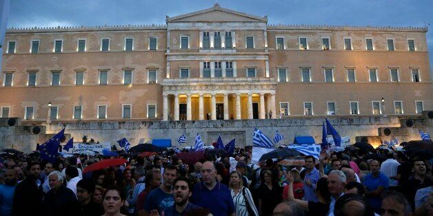 Demonstrators shout slogans during a rally organized by supporters of the YES vote to the upcoming referendum in front of the Greek Parliament in Athens, Tuesday, June 30, 2015 Greece's European creditors were assessing a last-minute proposal Athens made for a new two-year rescue deal, submitted just hours before the country's international bailout program expires and it loses access to billions of euros in funds. (AP Photo/Petros Karadjias)