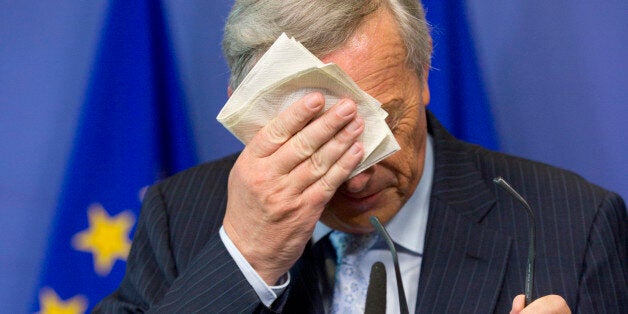 European Commission President Jean-Claude Juncker wipes his face during a media conference at EU headquarters in Brussels on