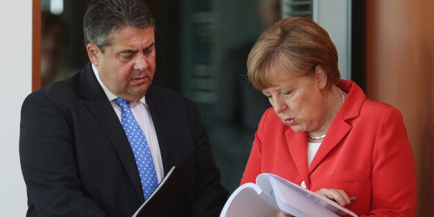 BERLIN, GERMANY - MAY 13: German Chancellor Angela Merkel and Vice Chancellor and Economy and Energy Minister Sigmar Gabriel look at an unidentified document prior to the weekly government cabinet meeting on May 13, 2015 in Berlin, Germany. The day before Wikileaks released full transcripts of hearings of the Bundestag commission tasked with investigating the role of the U.S. spy agency NSA's role in surveillance in Germany, including of German politicians and corporations. (Photo by Sean Gallup/Getty Images)