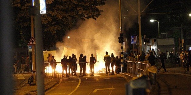 Protesters clash with riot police forces in The Hague's Schilderswijk district, the Netherlands, late June 29, 2015, after Mitch Henriquez from Aruba died in police custody on June 28. Henriquez was arrested on June 27 at the Night at the Park festival in The Hague after saying that he had a weapon. AFP PHOTO / ANP / ARIE KIEVIT -- The Netherlands out -- (Photo credit should read ARIE KIEVIT/AFP/Getty Images)