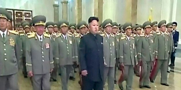 In this Tuesday, July 8, 2014 image made from video, North Korean leader Kim Jong Un, center, visits Kumsusan Palace of the Sun to mark the 20th anniversary of the death of its first leader, Kim Il Sung, in Pyongyang, North Korea. Kim seemed to have somehow hurt his leg enough to require a slight, but visible, limp as he marched across the stage Tuesday to assume his position of honor. He limped again as he left the room when the event was over. (AP Photo/KRT via AP Video) TV OUT, NORTH KOREA OUT