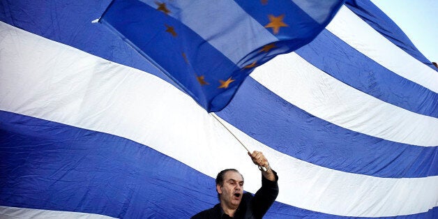 ATHENS, GREECE - JUNE 22: A man waves a EU flag as pro-Euro protesters take part in a rally in front of the Parliament on June 22. 2015 in Athens, Greece. Thousends of people attended the rally in support of Greece remaining in the European Union. The Eurozone's 19 national leaders held an emergency summit in Brussels to discuss the crisis and welcomed new proposals from the Greek government after talks today to haul Athens back from the brink of bankruptcy. (Photo by Milos Bicanski/Getty Images)