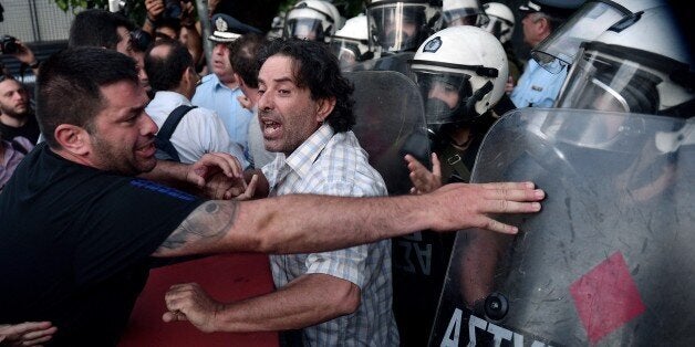 Anti-EU protesters scuffle with police outside the European Comission offices in Athens on July 2, 2015. Greece's government