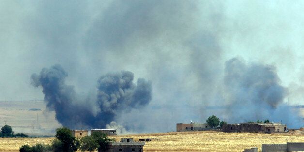 In this photo taken in Akcakale, Sanliurfa province, southeastern Turkey from the Turkish side of the border between Turkey and Syria, smoke from a US-led airstrike rises over the outskirts of Tal Abyad, Syria, Sunday, June 14, 2015. Syrian Kurdish fighters closed in on the outskirts of a strategic Islamic State-held town on the Turkish border Sunday, Kurdish officials and an activist group said, potentially cutting off a key supply line for the extremists' nearby de facto capital. Taking Tal Abyad, some 80 kilometers (50 miles) from the Islamic State stronghold of Raqqa, would mean the group wouldn't have a direct route to bring in new foreign militants or supplies.(AP Photo/Lefteris Pitarakis)
