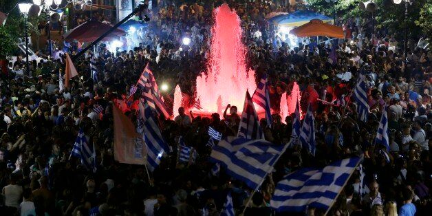 Supporters of the No vote wave Greek flags after the results of the referendum at Syntagma square in Athens, Sunday, July 5, 2015. Greece faced an uncharted future as officials counted the results of a referendum Sunday on whether to accept creditors' demands for more austerity in exchange for rescue loans, with three opinion polls showing a tight race with a narrow victory likely for the "no" side. (AP Photo/Petr David Josek)
