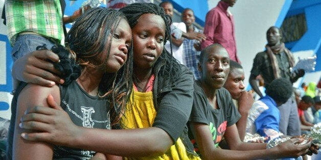 A survivor of an attack by islamist gunmen claimed by al-Shabab on a university campus in Garissa, northern Kenya is comforted by a colleague after arriving in Nairobi on April 4, 2015. Kenya's President, Uhuru Kenyatta vowed Saturday, to retaliate in the severest way against Somalia's al-Shabab islamists after they massacred nearly 150 people at a university. AFP PHOTO/Tony KARUMBA (Photo credit should read TONY KARUMBA/AFP/Getty Images)