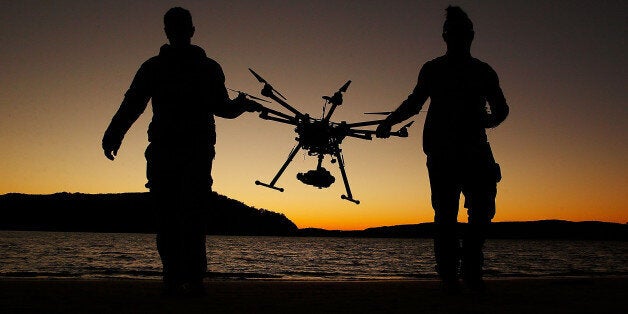 SYDNEY, AUSTRALIA - JULY 04: Drone operator, Ken Butti and Camera operator, Robbie Josephsen carry the custom built DJI s1000 Drone following a flight at Palm Beach on July 4, 2014 in Sydney, Australia. Commercial and recreational UAV (Unmanned Aerial Vehicles) sales in Australia have regulators concerned about safety, privacy and security, while the commercial industries of mining, farming, property, and sport are embracing the new technology. Under the current CASA (Civil Aviation Safety Authority) regulations all unmanned aircraft weighing more than 2kg need to have a UAS operators certificate. Licensed operators are not allowed to fly above 400ft, not within 5km of an airfield boundary and can't fly within 30 metres of people not involved with the operation. (Photo by Brendon Thorne/Getty Images)