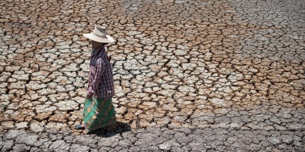 TO GO WITH Thailand-economy-rice-drought,FOCUS by Jerome TaylorThis picture taken on July 2, 2015 shows a Thai farmer walking on a dried out field in Bang Pla Ma district, Suphanburi province, a two-hour drive north of Bangkok. Thailand's vital rice belt is being battered by one of the worst droughts in living memory, forcing impoverished farmers deeper into debt and heaping fresh pain on an already weak economy -- seen as the junta's Achilles heel. AFP PHOTO / Nicolas ASFOURI (Photo credit should read NICOLAS ASFOURI/AFP/Getty Images)