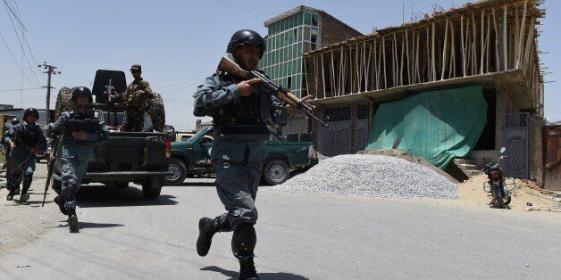 Afghan policemen run at the site of a suicide bomber that targeted NATO forces in Kabul on July 7, 2015. A Taliban suicide bomber targeted NATO forces in Kabul on July 7, officials said, as the Taliban step up attacks as part of their annual summer offensive. AFP PHOTO / SHAH Marai (Photo credit should read SHAH MARAI,SHAH MARAI/AFP/Getty Images)