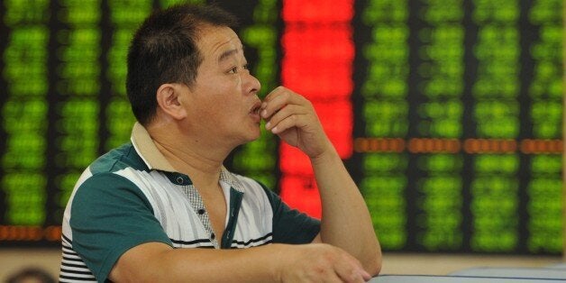 TO GO WITH China-economy-stocks, FOCUS by Fran WangThis photo taken on June 26, 2015 shows an investor checking the share prices in a stock firm in Fuyang, east China's Anhui province. When China's main share index hit a seven-year high earlier this month, it topped off a run that had seen it more than double in value over the past year, placing it among the world's top performers. AFP PHOTO CHINA OUT (Photo credit should read STR/AFP/Getty Images)