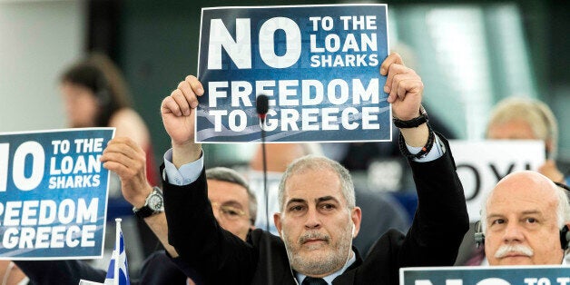 Far-right E.U Parliament members display posters before Greek Prime Minister Alexis Tsipras delivers his speech at the Europe