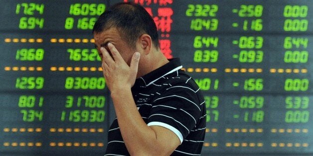 An investor reacts in front of a screen showing stock market movements in Fuyang, eastern China's Anhui province. Chinese shares took another tumble on July 7, defying government efforts to arrest a precipitous fall that has wiped an estimated $3.2 trillion off markets and threatens the world's number-two economy. AFP PHOTO CHINA OUT (Photo credit should read STR/AFP/Getty Images)