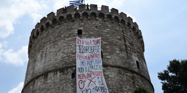 A banner hangs from the White Tower, a prominent landmark in the northern Greek city of Thessaloniki on Saturday, June 27, 2015. The banner, put up by the youth wing of the governing radical left Syriza party, reads, in Greek: "Peoples of Europe, rise! Rupture with austerity. No to fear." There is also the phrase "No to austerity," in English, French and German. Greece's fraught bailout talks with its creditors took a dramatic turn early Saturday, with the radical left government announcing a referendum in just over a week on the latest proposed deal â and urging voters to reject it. (AP Photo/Giannis Papanikos)