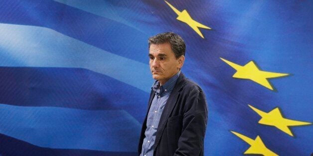 New Greek Finance Minister Euclid Tsakalotos arrives for a hand over ceremony in Athens, Monday, July 6, 2015. Following Sund