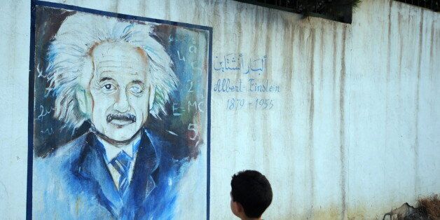 A boy looks at a wall showing a graffiti painting of Albert Einstein in Tunis, on July 11, 2010. AFP PHOTO / FETHI BELAID (Photo credit should read FETHI BELAID/AFP/Getty Images)