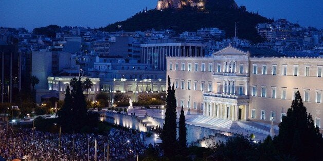 Pro-European Union protesters gather in front of the Greek parliament in Athens during a demonstration by a ' we stay in Europe' movement on July 9, 2015. Greece was to submit a detailed bailout request to its eurozone partners on July 9 in a last-ditch effort to save its collapsing economy and its place in the euro, in an unprecedented test of EU cohesion. With the crisis reaching a climax that could have unpredictable consequences, the EU president urged creditors to compromise on granting debt relief to Greece. AFP PHOTO/ LOUISA GOULIAMAKI- FRANCE OUT - (Photo credit should read LOUISA GOULIAMAKI/AFP/Getty Images)