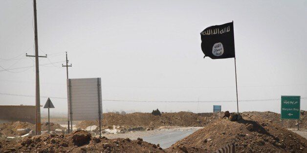 A flag of the Islamic State (IS) is seen on the other side of a bridge at the frontline of fighting between Kurdish Peshmerga fighters and Islamist militants in Rashad, on the road between Kirkuk and Tikrit, on September 11, 2014. Ten Arab states, including heavyweight Saudi Arabia, agreed today in Jeddah to rally behind Washington in the fight against Islamic State jihadists, as it seeks to build an international coalition. AFP PHOTO/JM LOPEZ (Photo credit should read JM LOPEZ/AFP/Getty Images)
