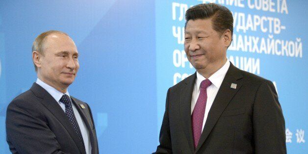 Russian President Vladimir Putin (L) greets Chinese President Xi Jinping during a welcome ceremony in Ufa on July 10, 2015 at the start of the Shanghai Cooperation Organization (SCO) summit. AFP PHOTO / ALEXANDER NEMENOV (Photo credit should read ALEXANDER NEMENOV/AFP/Getty Images)