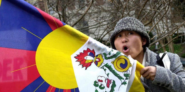 WASHINGTON, UNITED STATES: A protester waving a Tibetan flag chants slogans calling for the release of jailed Tibetan Buddhist teacher Tenzin Delek Rinpoche, who was arrested by Chinese authorities in April 2002 and sentenced to death 02 December of the same year, during a demonstration in front of the Chinese embassy in Washington 02 December 2004. Tenzin Delek Rinpoche was the target of Chinese authorities for many years because of his efforts to protect and promote Tibetan religion and culture in his community of Lthang in eastern Tibet. AFP PHOTO/Nicholas KAMM (Photo credit should read NICHOLAS KAMM/AFP/Getty Images)