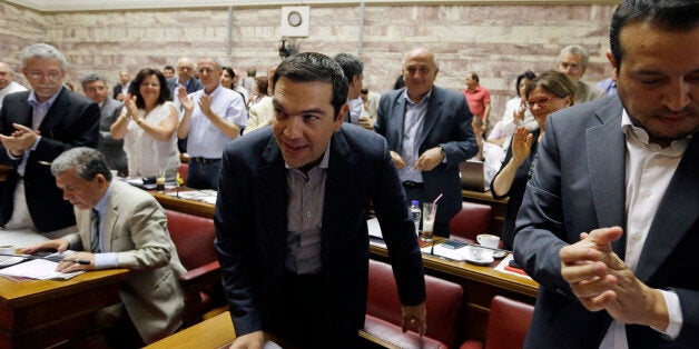 Greece's Prime Minister Alexis Tsipras arrives for a meeting as his lawmakers of Syriza party applaud him at the Greek Parliament in Athens, Friday, July 10, 2015. Tsipras will seek backing for a harsh new austerity package from his party Friday to keep his country in the euro â less than a week after urging Greeks to reject milder cuts in a referendum. (AP Photo/Thanassis Stavrakis)