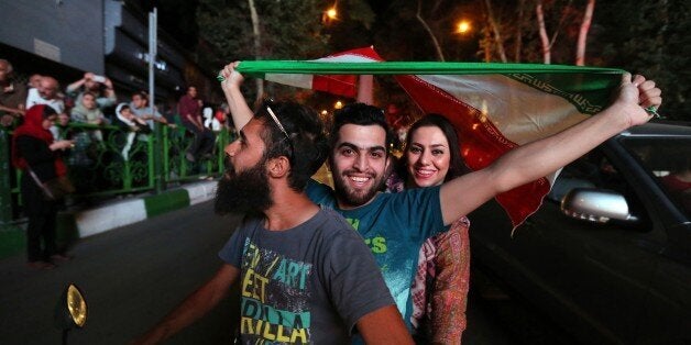 Iranian wave the national flag during celebration in northern Tehran on July 14, 2015, after Iran's nuclear negotiating team