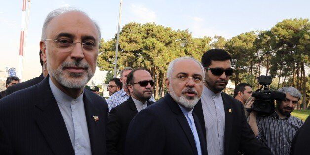Iranian Foreign Minister Mohammad Javad Zarif (C) and the head of Iran's Atomic Energy Organization Ali Akbar Salehi (L) arrive at Tehran's Mehrabad Airport on July 15, 2015, after Iran's nuclear negotiating team struck a deal with world powers in Vienna. Iran's negotiating team arrive back home saying a deal with world powers has solved a 'manufactured crisis' over its nuclear programme, while US conservatives bristle at the accord. AFP PHOTO/ATTA KENARE (Photo credit should read ATTA KENARE/AFP/Getty Images)