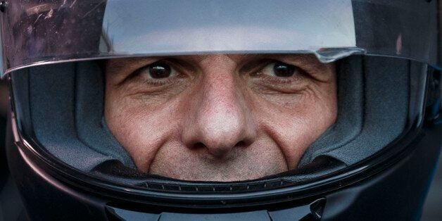 FILE - In this photo taken on Wednesday, July 1, 2015 Greece's Finance Minister Yanis Varoufakis puts on his motorbike helmet