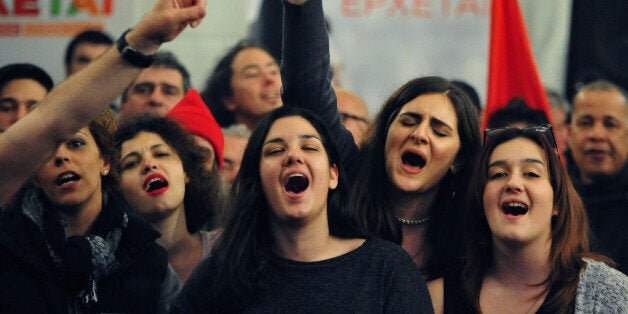 Supporters of left-wing Syriza party sing at the election kiosk in Athens, Sunday, Jan. 25, 2015. Greek election officials say the anti-austerity Syriza party has won Sunday's vote, but it is too soon to say whether it has enough support to form a governing majority. (AP Photo/Fotis Plegas G.)