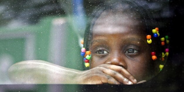 An Haitian girl looks from the window of a vehicle as her family is transported to be voluntarely repatriated in Santo Doming