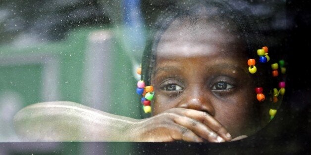 An Haitian girl looks from the window of a vehicle as her family is transported to be voluntarely repatriated in Santo Domingo on June 29, 2015. Some Haitians have chosen for volunteer repatriation before the start of the deportations of those who do not comply with the Dominican National Reorganization Plan for Foreigners. AFP PHOTO/ERIKA SANTELICES (Photo credit should read ERIKA SANTELICES/AFP/Getty Images)