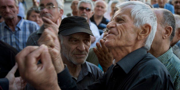 Elderly people argue with a bank worker as they wait to be allowed into the bank to withdraw a maximum of 120 euros ($134) for the week in Athens, Monday, July 6, 2015. Greeceâs Finance Minister Yanis Varoufakis has resigned following Sundayâs referendum in which the majority of voters said ânoâ to more austerity measures in exchange for another financial bailout. (AP Photo/Emilio Morenatti)