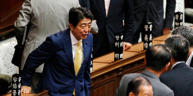 Japanese Prime Minister Shinzo Abe, left, greets his ruling party lawmakers after a plenary session at the lower house in Tokyo, Thursday, July 16, 2015. Japan's lower house of parliament on Thursday approved legislation that would allow an expanded role for the nation's military in a vote boycotted by the opposition. (AP Photo/Shuji Kajiyama)