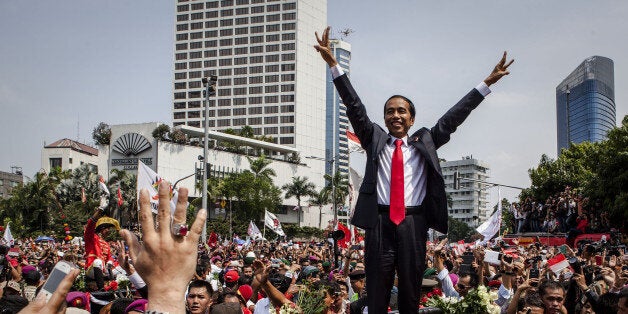 JAKARTA, INDONESIA - OCTOBER 20: Indonesian President Joko Widodo waves to crowds while on his journey to Presidential Palace by carriage during the ceremony parade on October 20, 2014 in Jakarta, Indonesia. Joko Widodo is today sworn in as the president of Indonesia with an inauguration ceremony held in Jakarta. Widodo was the eventual winner of a tightly fought and sometimes controversial election race against opposition candidate Prabowo Subianto. A number of key world leaders will be in attendance including Australia's prime minister Tony Abbott. (Photo by Ulet Ifansasti/Getty Images)