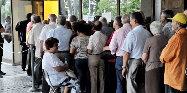 People queue outside of a National bank branch in Thessaloniki on July 10, 2015. Lawmakers in Greece will vote whether to bac