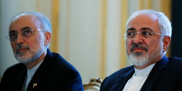 Iranian Foreign Minister Mohammad Javad Zarif and the Head of the Iranian Atomic Energy Organization Ali Akbar Salehi, left, meet with U.S. Secretary of State John Kerry in Vienna, Austria, Friday July 3, 2015. Iran has committed to implementing the IAEA's "additional protocol" for inspections and monitoring as part of an accord, but the rules don't guarantee international monitors can enter any facility including sensitive military sites, so making it difficult to investigate allegations of secret work on nuclear weapons. (Carlos Barria/Pool via AP)