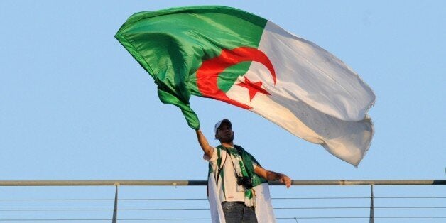 An Algeria football team fan waves an Algerian flag during the match between Togo and Algeria at the 2013 African Cup of Nations in Rustenburg on January 26, 2013. AFP PHOTO / ALEXANDER JOE (Photo credit should read ALEXANDER JOE/AFP/Getty Images)